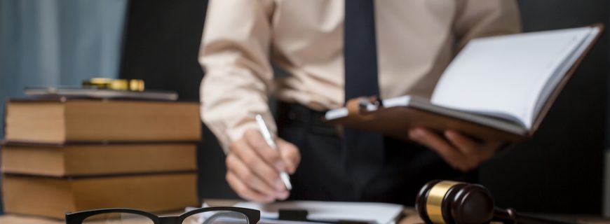 Business lawyer working hard at office desk workplace with book and documents.